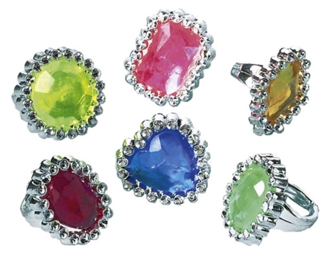 Sechs Ringe mit bunten, facettierten Steinen. Farben: grün, gelb, pink, blau, rot, orange. Silberne Fassung mit kleinen, glänzenden Steinen.