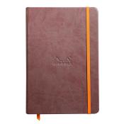 Braunes Notizbuch mit orangefarbener Gummiband. Auf der Vorderseite ist das Logo 'Rhodia' eingeprägt.
