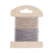 Zwei Spulen mit dünnem Garn in hellbeige und silber. Die Spulen sind auf einem Holzträger befestigt.
