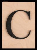 Holzplatte mit schwarzem Buchstaben C. Der Buchstabe ist groß und klar sichtbar.