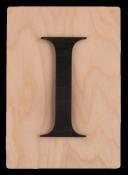 Holzplatte mit schwarzem Buchstaben 'I'. Der Hintergrund ist hell und glatt.