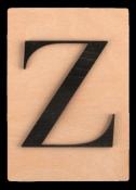 Holzplatte mit schwarzem Buchstaben Z. Der Buchstabe hat eine elegante Form.