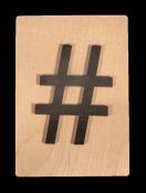 Holzplatte mit schwarzem Hashtag-Symbol. Schlichtes Design auf hellem Hintergrund.