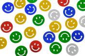 Bunte Smileys auf runden Plättchen. Farben: rot, grün, blau, gelb, silber. Lächelnde Gesichter, einige mit Pfeilen.