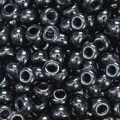Schwarze, glänzende Perlen aus Glas. Rund, mit einem Loch in der Mitte. Viele Perlen dicht beieinander.
