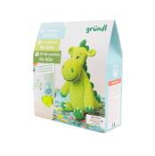 Häkelset für einen grünen Dinosaurier namens Dino Dieter. Verpackung zeigt das fertige Produkt und enthält Anleitungen.