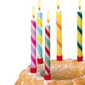 Ein runder Kuchen mit fünf bunten Kerzen. Die Kerzen brennen und sind in verschiedenen Farben.