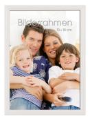 Familienfoto mit vier Personen. Lächelnde Gesichter, entspannte Pose. Kinder in gestreiften Shirts, Erwachsene in lässiger Kleidung. Sofaeinstellung.