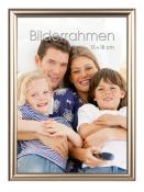 Familienfoto mit vier Personen auf einem Sofa. Lächelnde Gesichter, zwei Kinder und zwei Erwachsene.