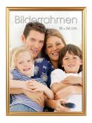 Familienfoto mit vier Personen auf einem Sofa. Lächelnde Gesichter, zwei Kinder und zwei Erwachsene.