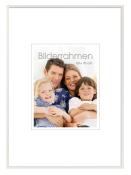 Familienfoto mit vier Personen. Zwei Kinder und zwei Erwachsene. Lächelnde Gesichter. Helle, freundliche Umgebung.