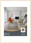 Helles Wohnzimmer mit einem orangefarbenen Sessel. Ein kleiner Tisch mit einem Buch und einer Brille.
