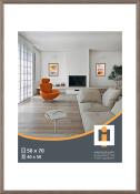 Helles Wohnzimmer mit einem orangefarbenen Sessel. Es gibt einen Tisch und zwei Bilder an der Wand.
