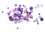 Bunte, facettierte Glasperlen in verschiedenen Lila- und Violetttönen. Die Perlen sind in unterschiedlichen Größen und Formen.