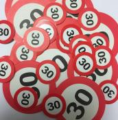 Eine Ansammlung von roten Spielmarken mit der Zahl 30. Die Marken sind in verschiedenen Größen und Formen.