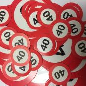 Viele rote Plaketten mit der Zahl 40. Runde Form, weißer Hintergrund.