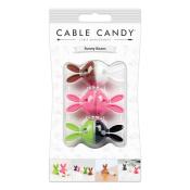 Set von vier Kabelhaltern in Form von Hasen. Farben: braun, weiß, pink, grün, schwarz. Verpackung zeigt verschiedene Anwendungsmöglichkeiten.