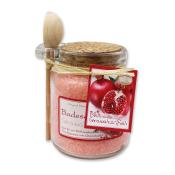 Glasbehälter mit Badesalz. Rosa Farbe, Holzlöffel oben. Korkenverschluss. Etikett mit Granatapfel-Motiv.