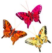 Drei bunte Schmetterlinge in verschiedenen Farben. Sie sind aus Kunststoff und haben auffällige Muster.