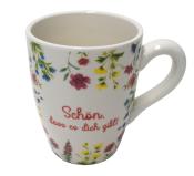 Weiße Tasse mit bunten Blumenmustern. Auf der Tasse steht der Text: 'Schön, dass es dich gibt!'