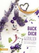 Buchcover mit dem Titel 'Back dich glücklich'. Dekoriert mit lila Blumen und einer Torte.