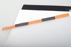 Schwarzes Notizbuch mit orangefarbenem Aufkleber. Es ist nachfüllbar und aus recyceltem Material.