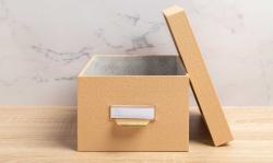 Drei stapelbare Aufbewahrungsboxen in beige. Jede Box hat einen Deckel und einen Griff.