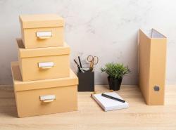 Drei stapelbare Aufbewahrungsboxen in beige. Jede Box hat einen Deckel und einen Griff.