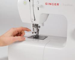 Nähmaschine in Weiß mit verschiedenen Einstellknöpfen. Markierung 'Singer Tradition' sichtbar.