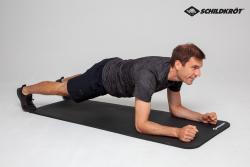 Schwarze Yoga-Matte mit geriffelter Oberfläche. Sie ist aufgerollt und hat ein Logo in der Ecke.