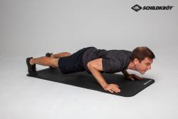 Schwarze Yoga-Matte mit geriffelter Oberfläche. Sie ist aufgerollt und hat ein Logo in der Ecke.