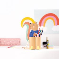 Bastelbox mit bunten Papierfiguren. Enthält Pinguine, Fische, ein Tier mit Pullover und Bastelmaterialien. Farbenfroh und kinderfreundlich.
