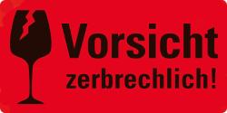 Rote Warnetiketten mit dem Text 'Vorsicht zerbrechlich!'. Verpackung zeigt eine gelbe Box mit Etiketten für den Paketversand.