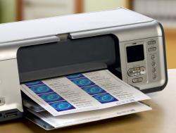 Visitenkarten mit mikroperforierter Kante. Enthält Beispielinformationen und wird in einem Drucker verwendet.