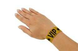Gelbes VIP-Armband mit schwarzen Sternen und dem Schriftzug VIP. Es hat eine weiße Markierung.