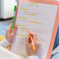 Vier Textmarker in leuchtenden Farben grün, pink, orange und gelb. Dazu gehören passende Kappen in denselben Farben.