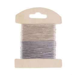 Zwei Spulen mit dünnem Garn in hellbeige und silber. Die Spulen sind auf einem Holzträger befestigt.