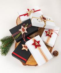 Sechs schwarze Geschenkboxen in rechteckiger Form. Eine Box ist offen und zeigt den Innenraum.