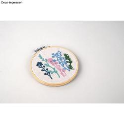 Stickset mit bunten Pflanzenmotiven. Im Stickrahmen, auf hellem Stoff.