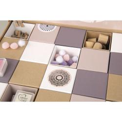 Aufbewahrungsbox mit verschiedenen Fächern. Enthält bunte Pompons, Holzklötze und Stempel.