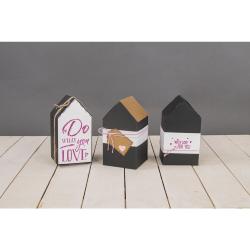 schwarze Pappbox in Form eines Hauses. Spitzdach, einfache geometrische Form. Keine weiteren Verzierungen.