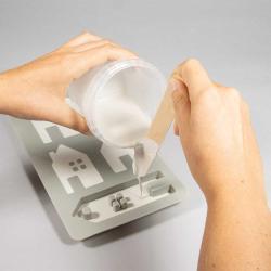 Silikonform mit verschiedenen Hausformen und einem Anhänger. Die Formen haben kleine Details wie Herzen und Fenster.