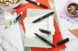 schwarzer Stift mit ergonomischem Design. Der Stift hat eine Kappe und eine glatte Oberfläche.
