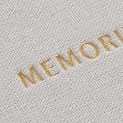 Ein graues Fotoalbum mit dem Titel 'MEMORIES' in goldener Schrift. Der Einband ist aus Stoff.