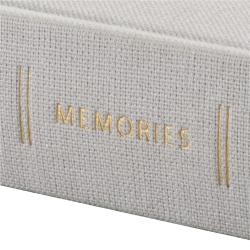 Ein graues Fotoalbum mit dem Titel 'MEMORIES' in goldener Schrift. Der Einband ist aus Stoff.