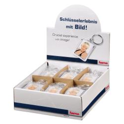 Schlüsselanhänger mit einem Foto einer Person. Die Person hat kurzes, helles Haar und trägt ein schwarzes Oberteil.