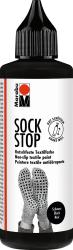 Schwarze Flasche mit spitzem Ausguss. Aufschrift 'SOCK STOP'. Rutschfeste Textilfarbe für Socken. Abgebildete Socken mit rutschfester Unterseite.