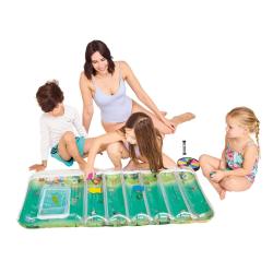 Spielset 'Tempo, kleine Fische! Splash'. Bunte Verpackung. Enthält Spielbrett und Luftmatratze. Für 2-5 Spieler, ab 3 Jahren. Abgebildete Kinder und Erwachsene spielen im Wasser.