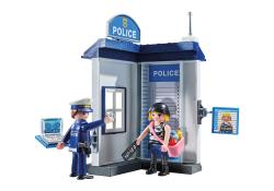 Spielzeug Polizei-Station mit zwei Figuren. Ein Polizist und eine Person mit einem Schild stehen vor dem Gebäude.