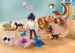 Spielzeugfigur mit Katzen in einem Raum. Katzenklo und Spielzeug vorhanden.